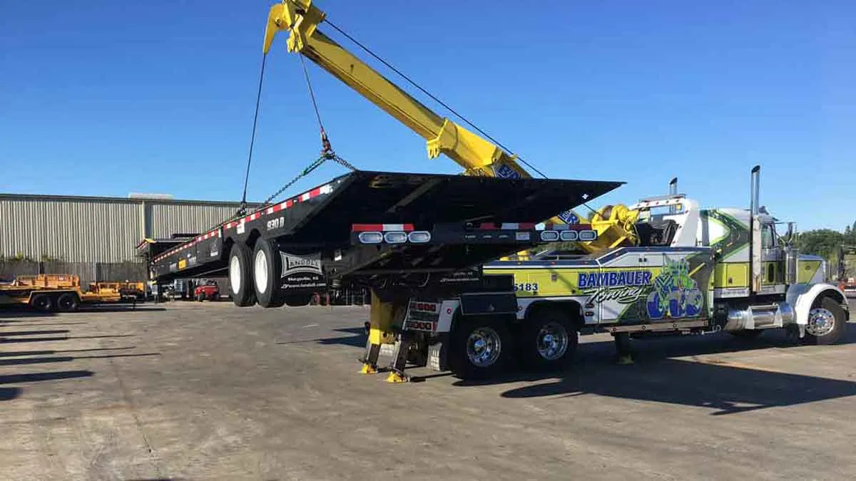 Bambauer wrecker lifting a flatbed trailer at a work site